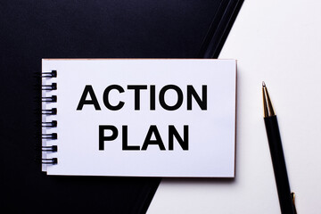 The words ACTION PLAN written in red on a black and white background near the pen