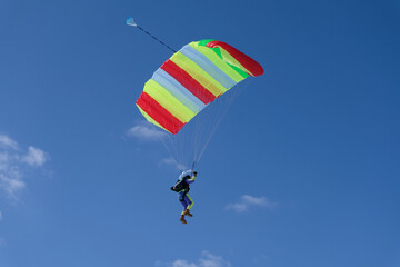 Skydiving. A parachute is in the blue sky.