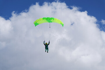 Skydiving. A parachute is in the blue sky.