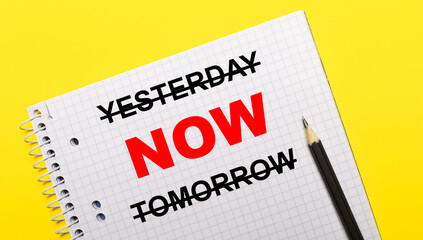 Obraz premium White notebook with inscription YESTERDAY NOW TOMORROW written in black pencil on a bright yellow background.