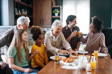 Multi ethnic and generational family cooking in kitchen together - Powered by Adobe