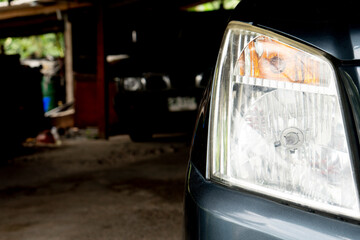 Close up of car headlight that becomes cloudy after a long time use. Cars parked in the parking lot.