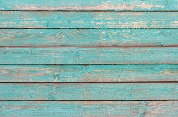 The wooden wall of an old wooden house, painted blue.