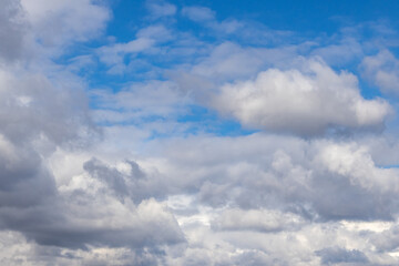 Detail of a white cloud in a bright blue sky. 
Dark rain clouds displace the blue sky. Storm is coming. Cumulus clouds on a sunny Day. 