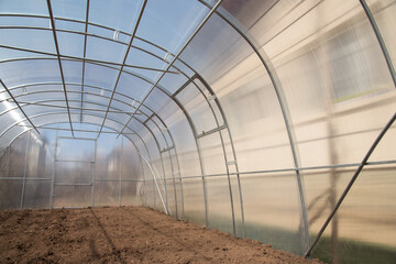 Empty greenhouse, prepared for planting vegetables in the spring. Home production of vegetables.