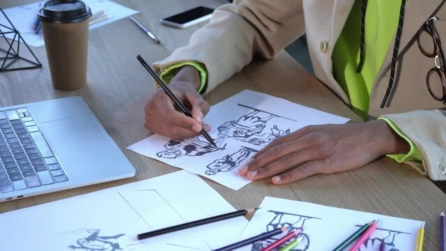 cropped view of african american illustrator drawing character on paper