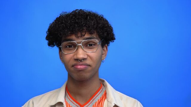young and pierced african american man nodding isolated on blue