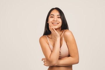 Photo of natural woman face, wears top. Isolated over white background. Natural beauty and health. Clean skin and cute smile