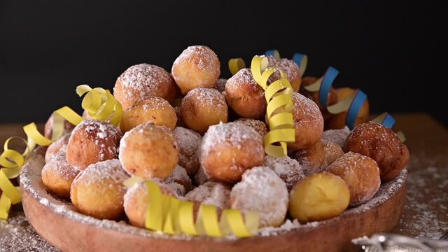 Falling confetti on buns in powdered sugar. Traditional Venetian carnival and food TYPICAL. Coffee, Sfrappole or chiachiere or angel wings and aromatic coffee on a bright blue background. Slow-motion