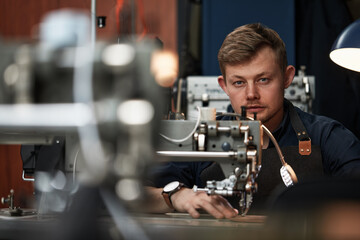 Working process of leather craftsman. Tanner or skinner sews leather on a special sewing machine, close up.worker sewing on the sewing machine