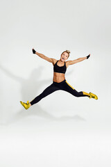 Fototapeta na wymiar athletic blonde woman in black sportswear jumping