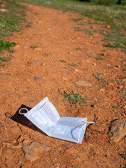 Face mask lying on a dirt road