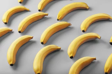 Geometrisches Muster aus gelben Bananen auf grauem Hintergrund in den modischen Farben von 2021. © Alexander