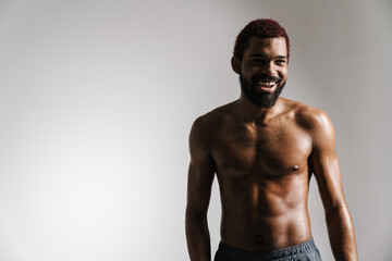 Fototapeta premium Black shirtless sportsman smiling and looking aside