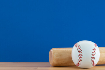 Close up baseball and baseball bat on wooden table with blue copy space background, sport concept