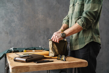 White craftsman working with leather while standing in workshop