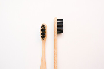 Fototapeta na wymiar Two bamboo toothbrushes close-up on a white background. zero waste concept, environmentally friendly modern simple idea, copy space. Oral, teeth and gum care. top view