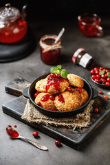 Cottage cheese pancakes. Syrniki with jam on grey background