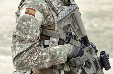 Soldier with assault rifle and flag of Spain on military uniform. Collage.