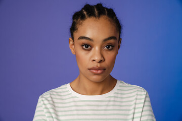 Young black woman in t-shirt posing and looking at camera