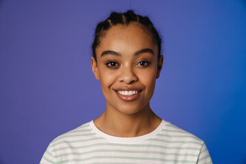 Young black woman in t-shirt smiling and looking at camera