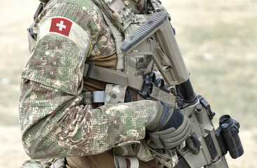 Soldier with assault rifle and flag of Switzerland on military uniform. Collage.