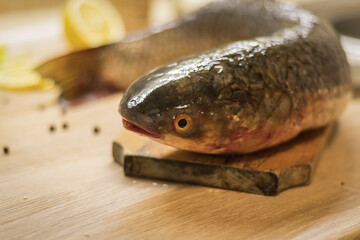 Fish. There is a raw fish cut into pieces on the kitchen board. And the whole thing.