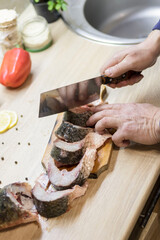 Fish. There is a raw fish cut into pieces on the kitchen board. And the whole thing.