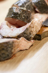 Fish. There is a raw fish cut into pieces on the kitchen board. And the whole thing.