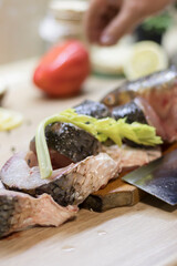 Fish. There is a raw fish cut into pieces on the kitchen board. And the whole thing.