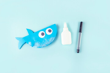 DIY and kids creativity. Step by step instruction: how to make shark from paper. Step8 Glue fin. Children Craft workshop