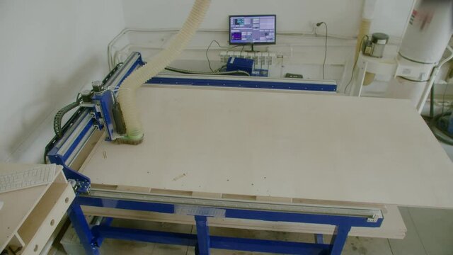 Milling machine cut letters out of plywood. Flying flakes shavings. Production of advertising signboard.