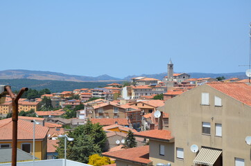 Nice view of a small town located in the mountains. Houses with orange-red roofs.