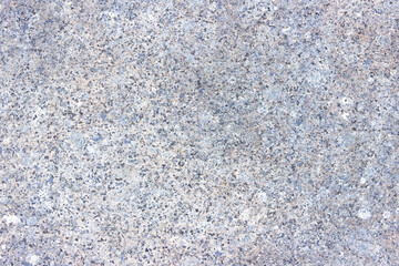 The texture of a hewn granite slab with a colorful pattern. Facing material for walls made of natural stone.
