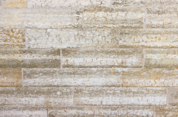 The wall is made of yellowish blocks of hewn limestone. Facing material made of natural stone.