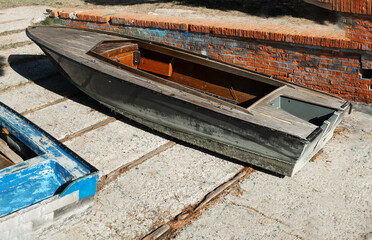 old wooden boats on the concrete embankment. Abandoned fishing boats 