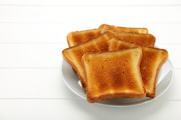 Pile of toasted bread slices on a single white plate On white background.