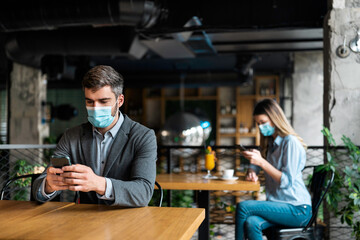 Social distance concept. Businessman in restaurant wearing mask