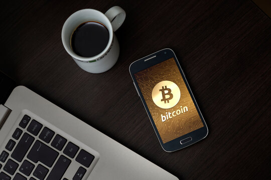 Bitcoin symbol on mobile smartphone app screen with golden circuit background. Bitcoin value grow concept. Technology, digital money. Flat lay photo.
