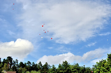 Hoch hinauffliegende rote und weiße Herz-Luftballons mit anhängender Karte 