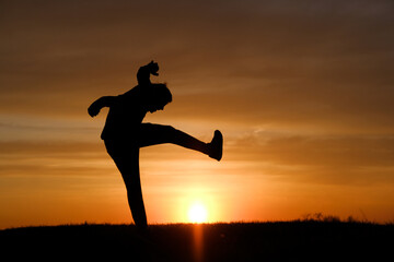 Fototapeta na wymiar Man silhouette jump at sunset background at summer.