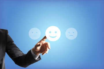Businessman hand touches the good emoticon, blue background