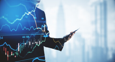 Businessman holding mobile phone in his hand, trade charts, trading concept