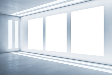 White wall with three blank white frames, empty room, artificially lit, concrete floor, interior advertisement concept, mockup