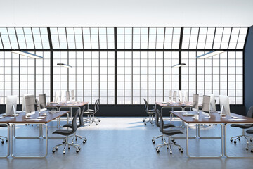 Loft style interior design of spacious coworking office with huge squared window, concrete floor and mdoern furniture