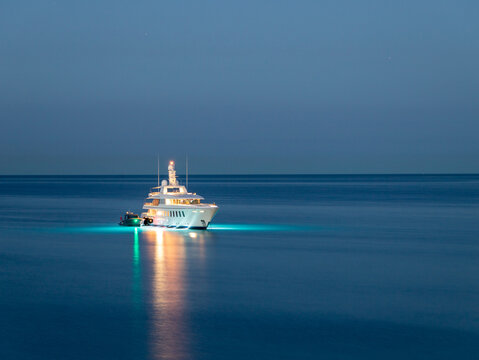 a close-up of a yacht she anchored on a sea to spend the night. Yacht with many lights on a dark sea. party on the sea 