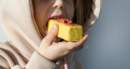 Child girl eats glazed sweets. Raw Food Sweets, Vegans, Vegetarians and Sugar Free.