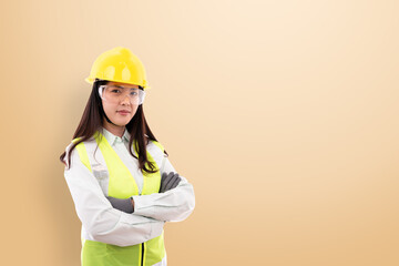 Female engineers wear yellow helmets, reflective vests and safety glasses and wear gloves.  And standing with arms folded, the idea is to wear safety equipment before work and work with safety.