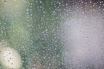 Drops of rain on window with abstract lights