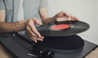 Young man listening to music, relaxing, enjoying life at home. Turntable playing vinyl LP record closeup. Leisure, music, hobby, lockdown, social distancing lifestyle concept